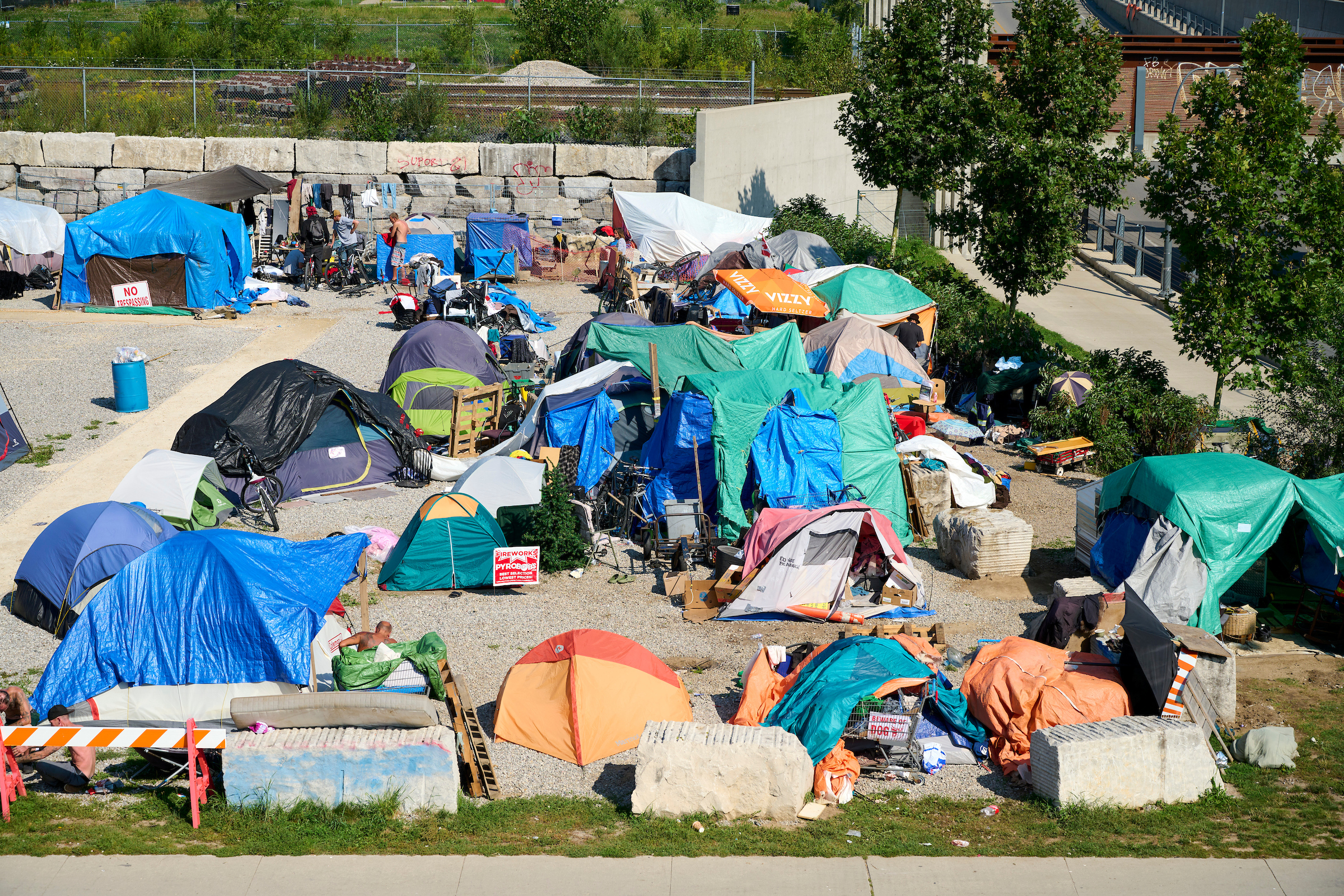 Aerial view of a large tent encampment at 100 Victoria Street North, Kitchener, Ontario, with colorful tents and makeshift shelters visible.