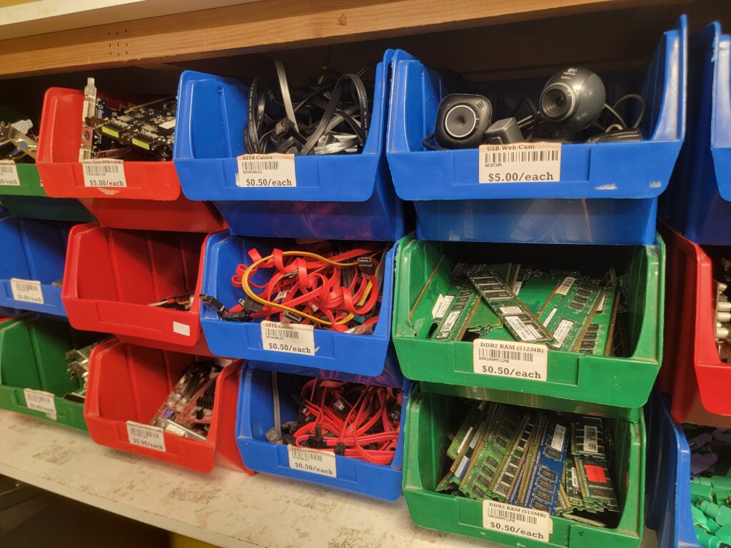 Color-coded bins filled with refurbished computer parts and accessories at The Working Centre's Computer Recycling Project in Kitchener, Ontario.