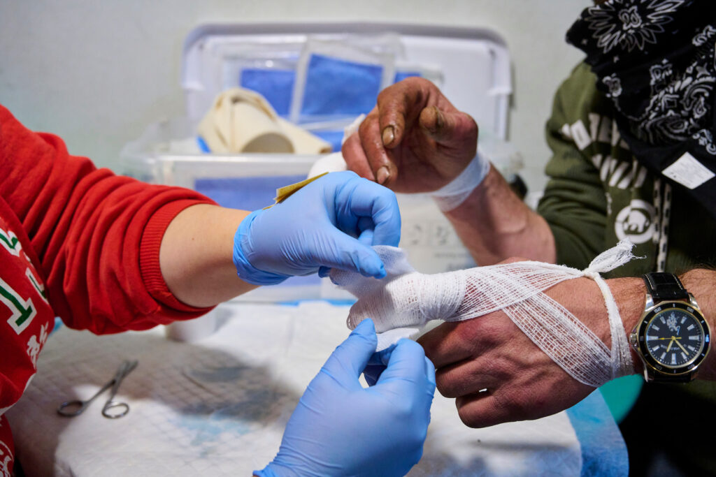 Emma, a registered nurse on the SOS outreach team, provides wound care by cleaning and dressing Rob's finger injuries in Kitchener, Ontario.