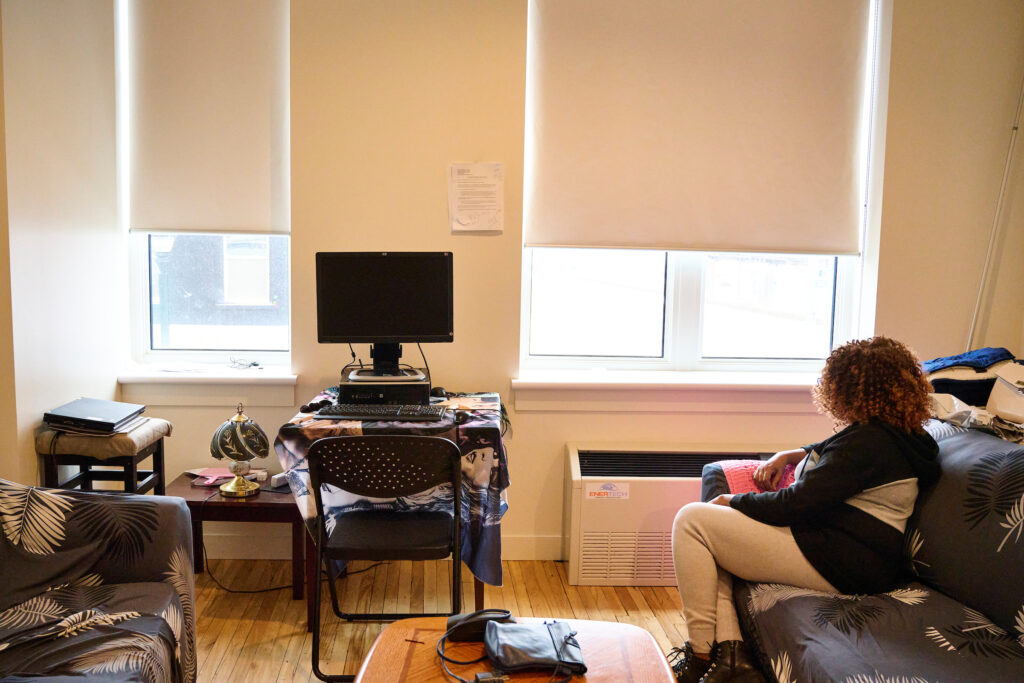 Woman sitting in Queen Street Apartments, Kitchener, Ontario.