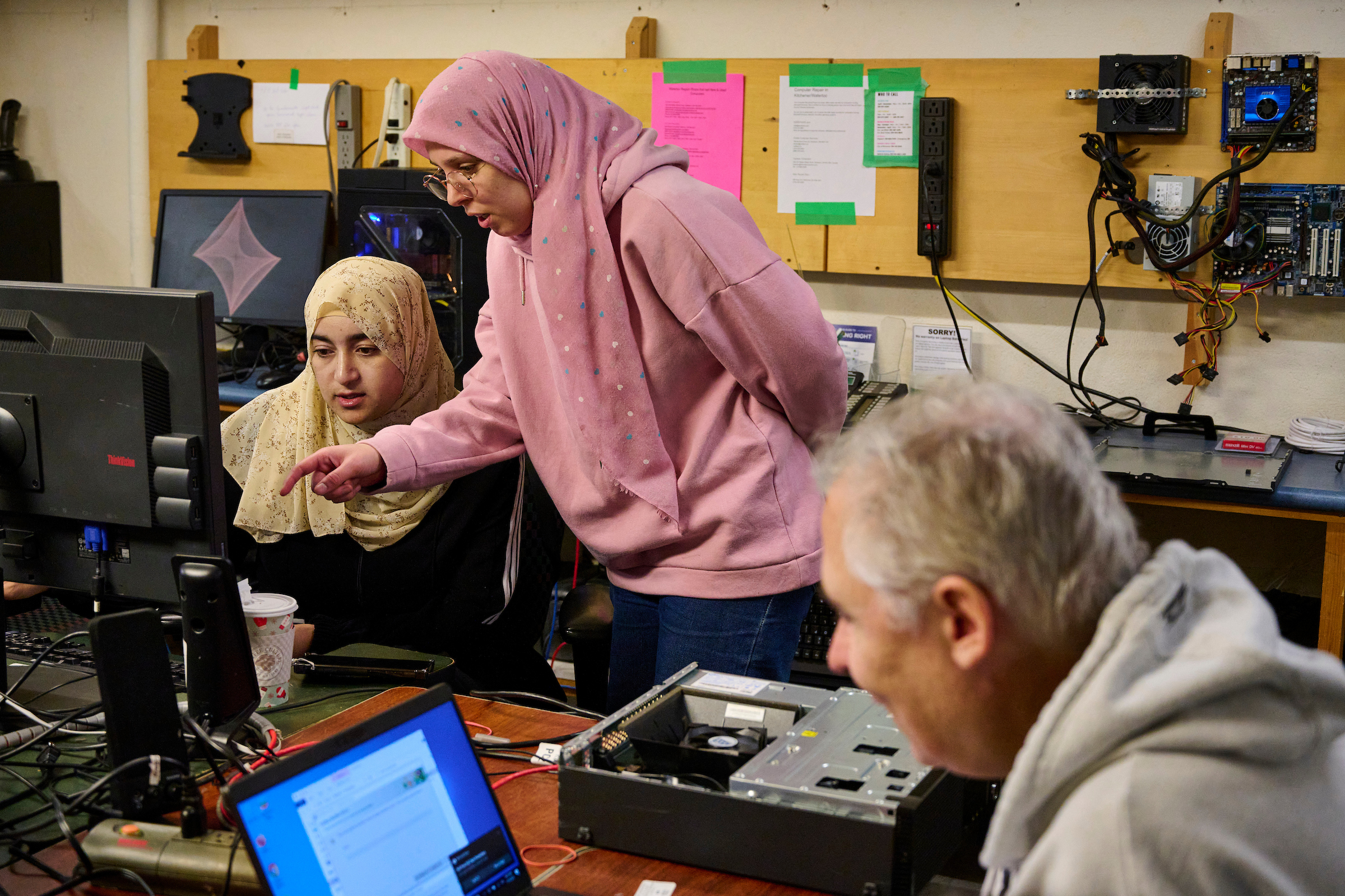 Staff and volunteer testing refurbished computers at Computer Recycling, part of The Working Centre's Community Tool projects in Kitchener, Ontario.