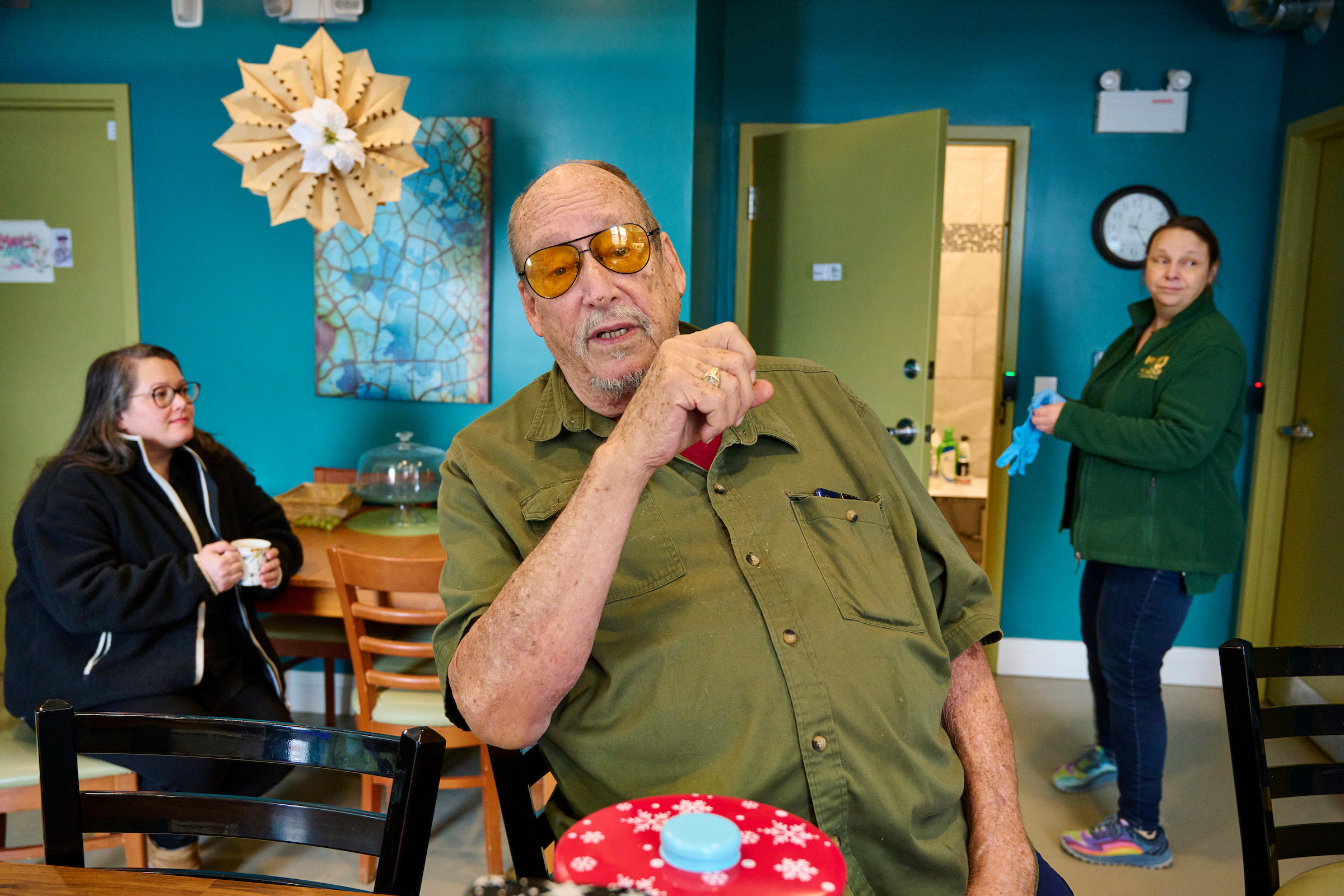 Tanya Roper, a staff member, Georg, a resident, and Leslie, a staff member, engaging in conversation at Hospitality House, Kitchener, Ontario.