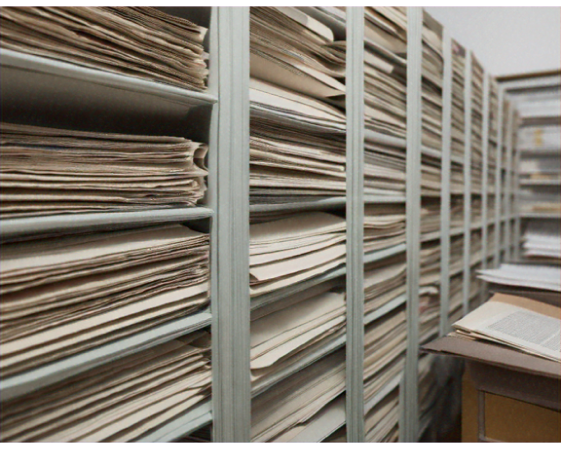 Rows of archived newspapers neatly organized on metal shelves.